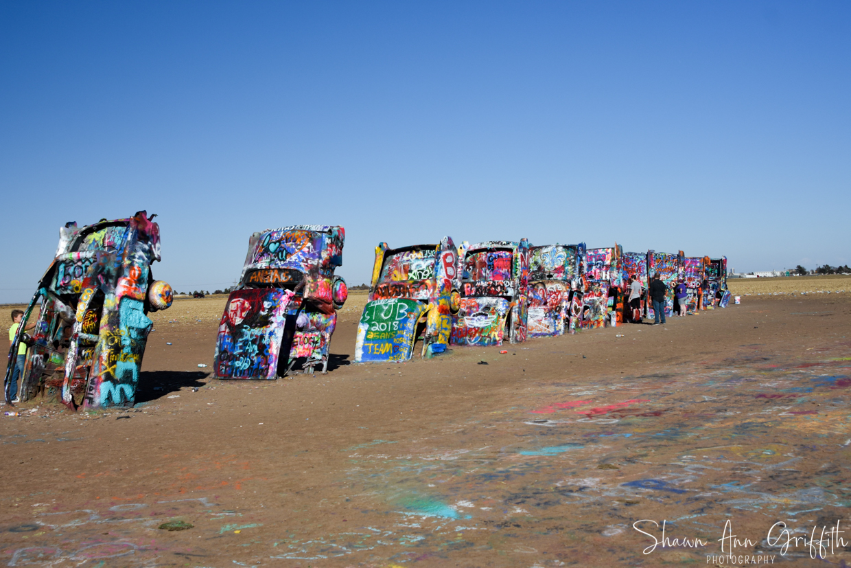 Cadillac Ranch consists of older running used & junk Cadillacs, representing the car line from 1949 to 1963, half-buried nose-first in the ground.